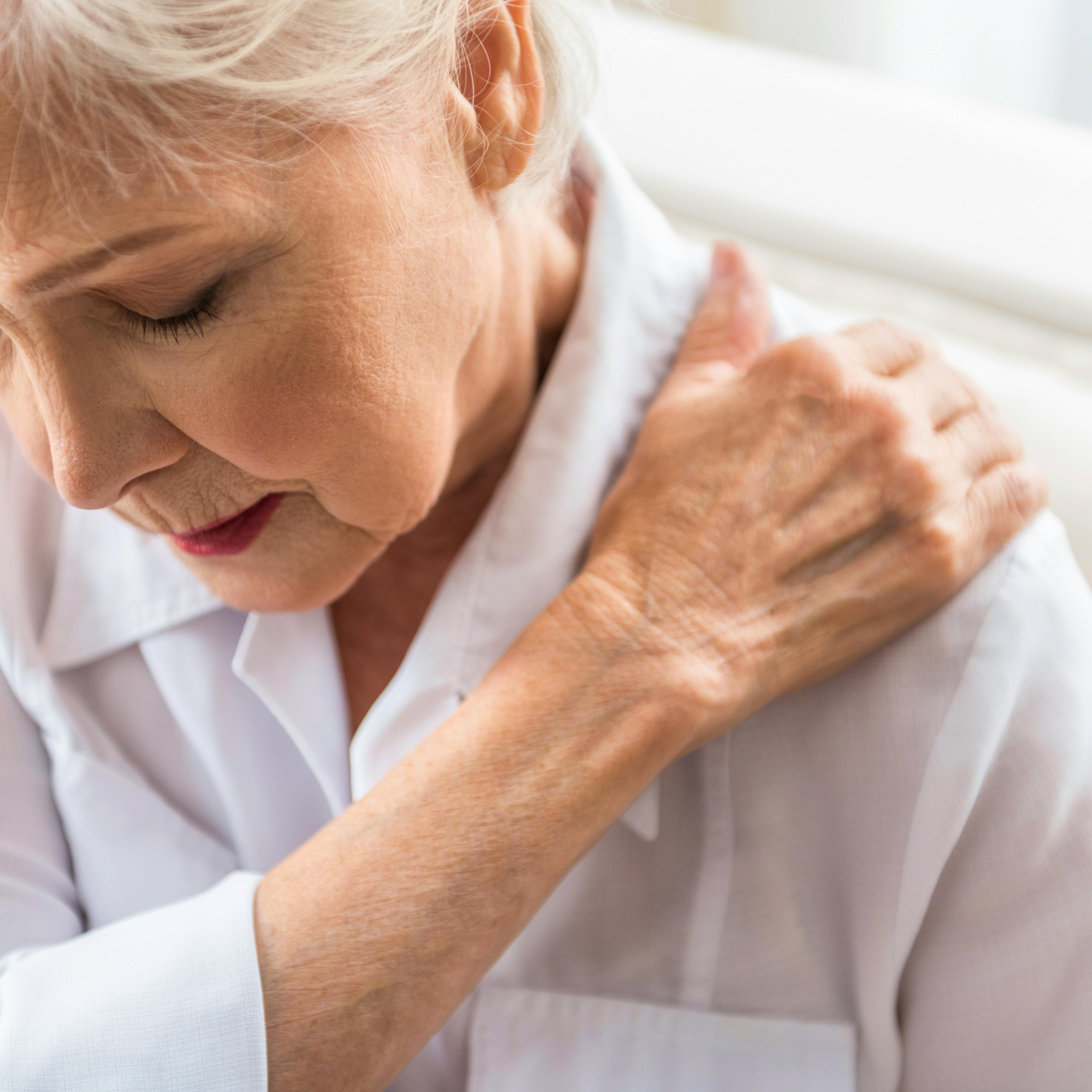 An elderly woman is experiencing shoulder pain.