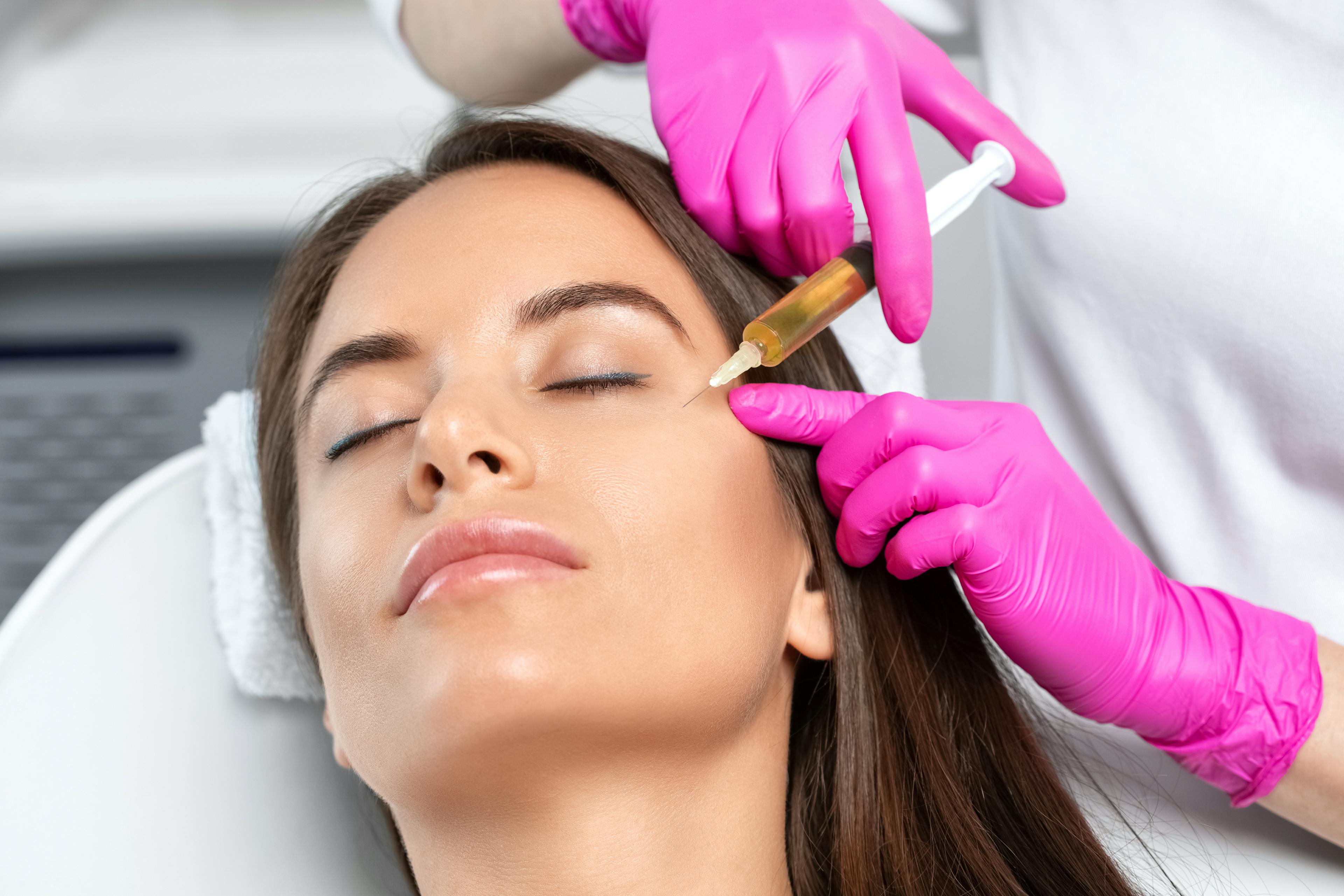 Women receiving prp injection on the side of her face from doctor