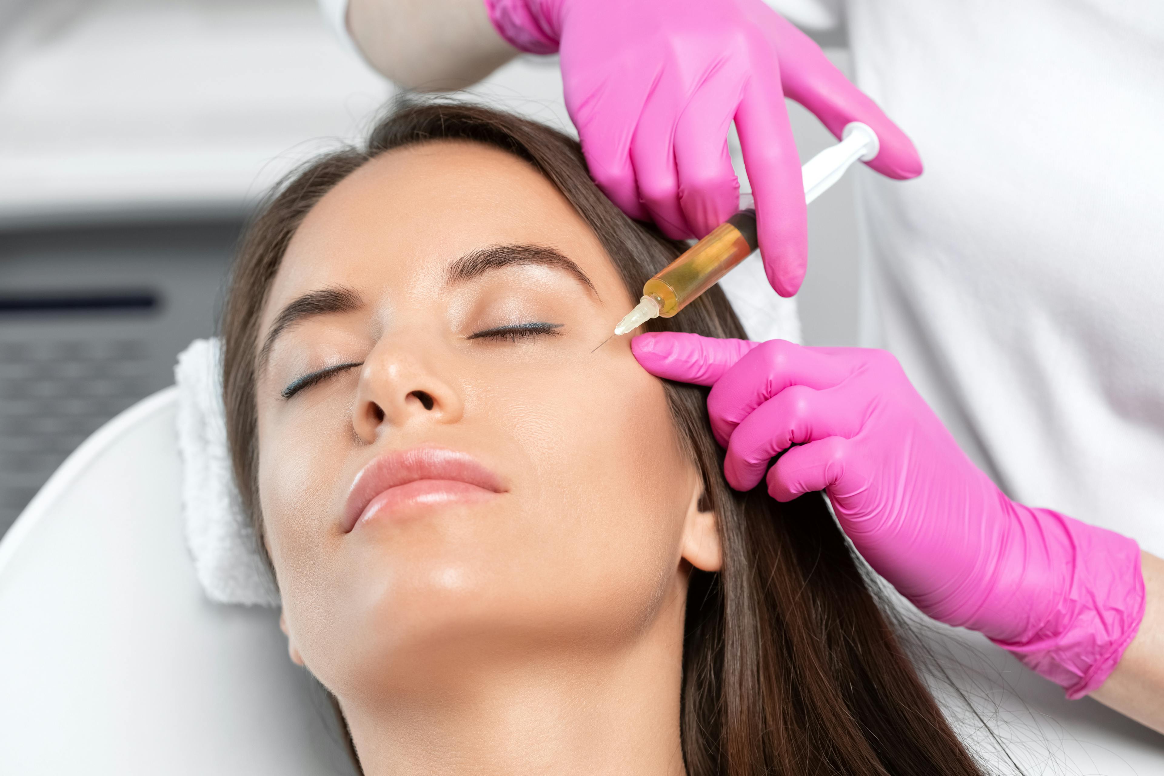 Women receiving prp injection on the side of her face from doctor