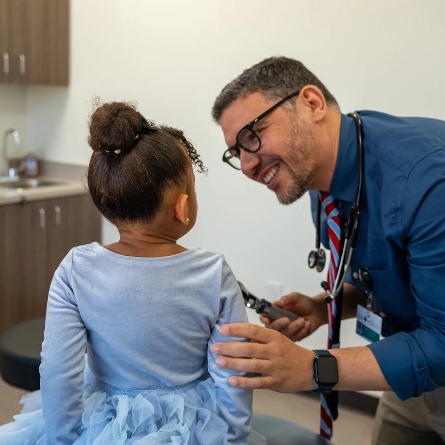 Dr. Khaled Mohammed, pediatrician, doing a wellness check on a kid.