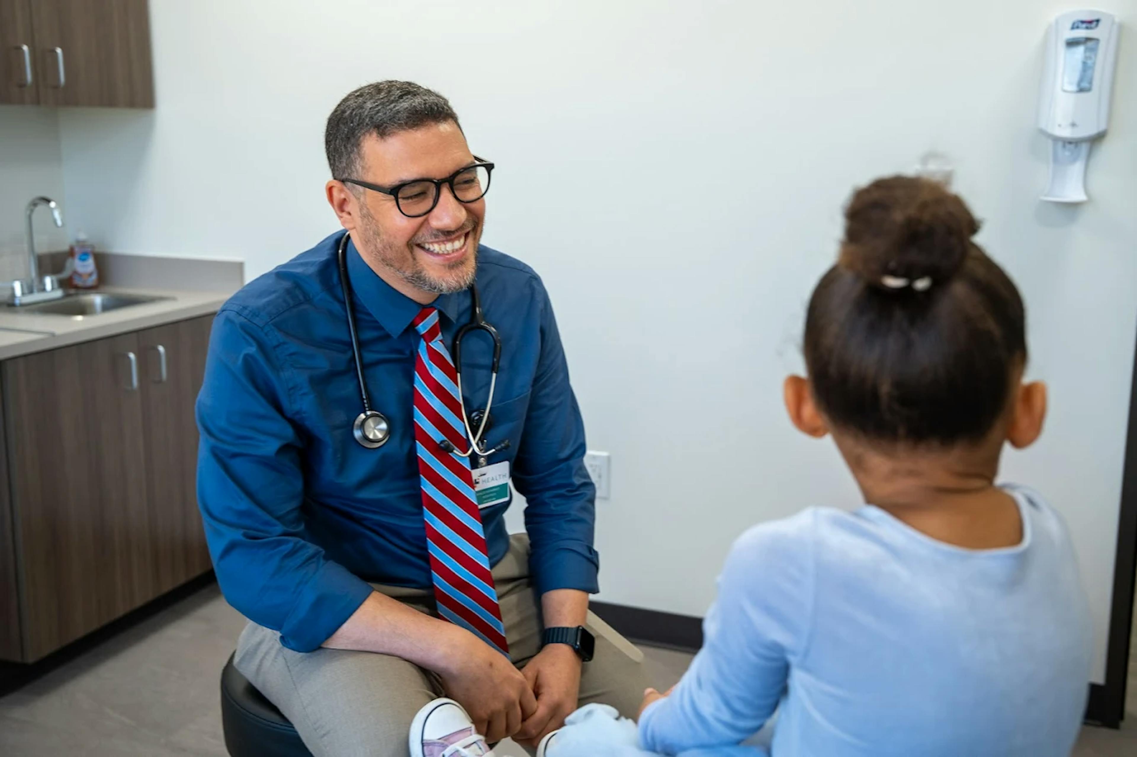 Dr. Khaled Mohammed, pediatrician, performing an annual wellness check on a patient in Sugar Land.