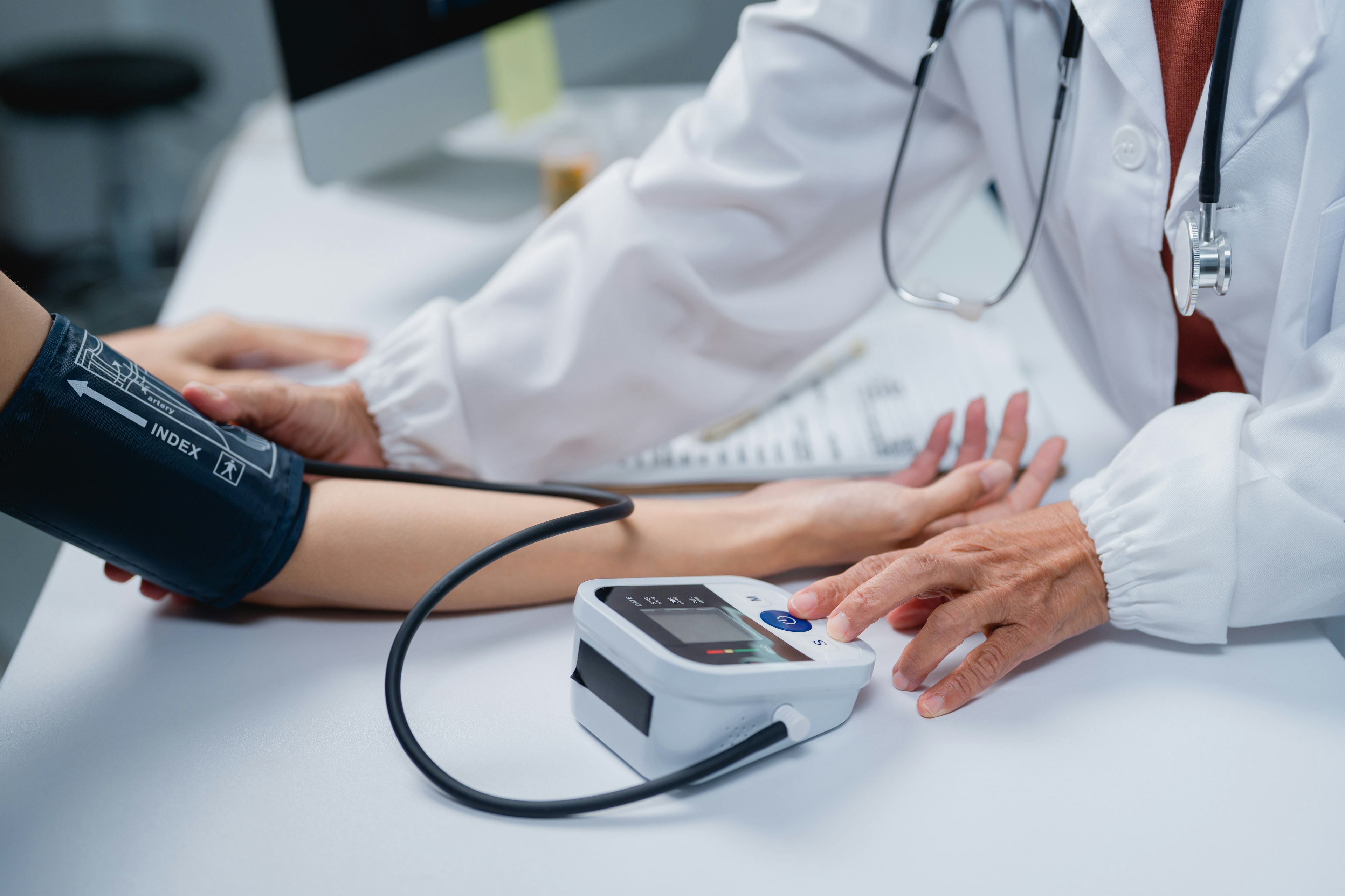 Doctor checking patient's blood pressure for hypertension screening.