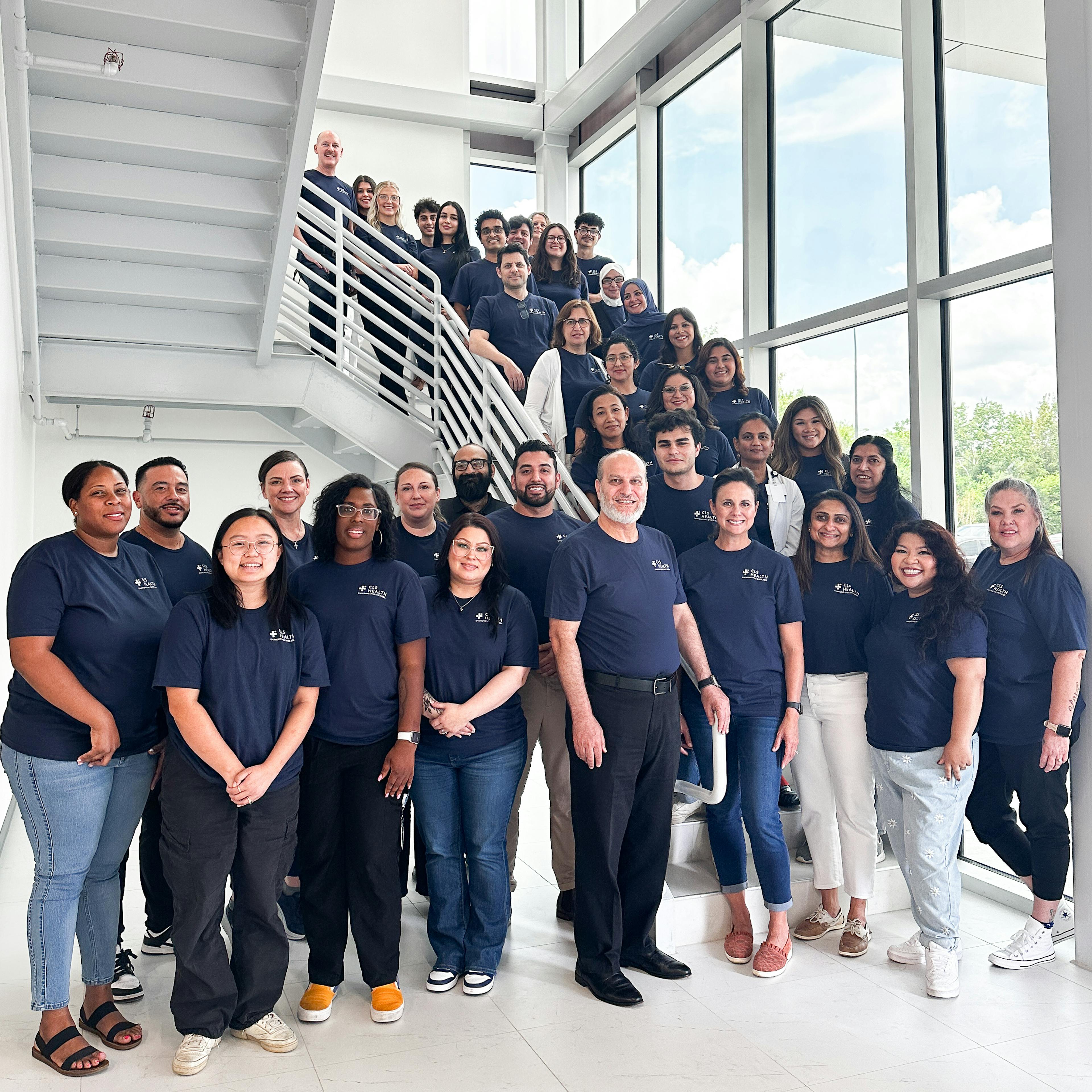 CLS Health employees in their company tshirts posing together for a photo at the Clear Lake clinic. 
