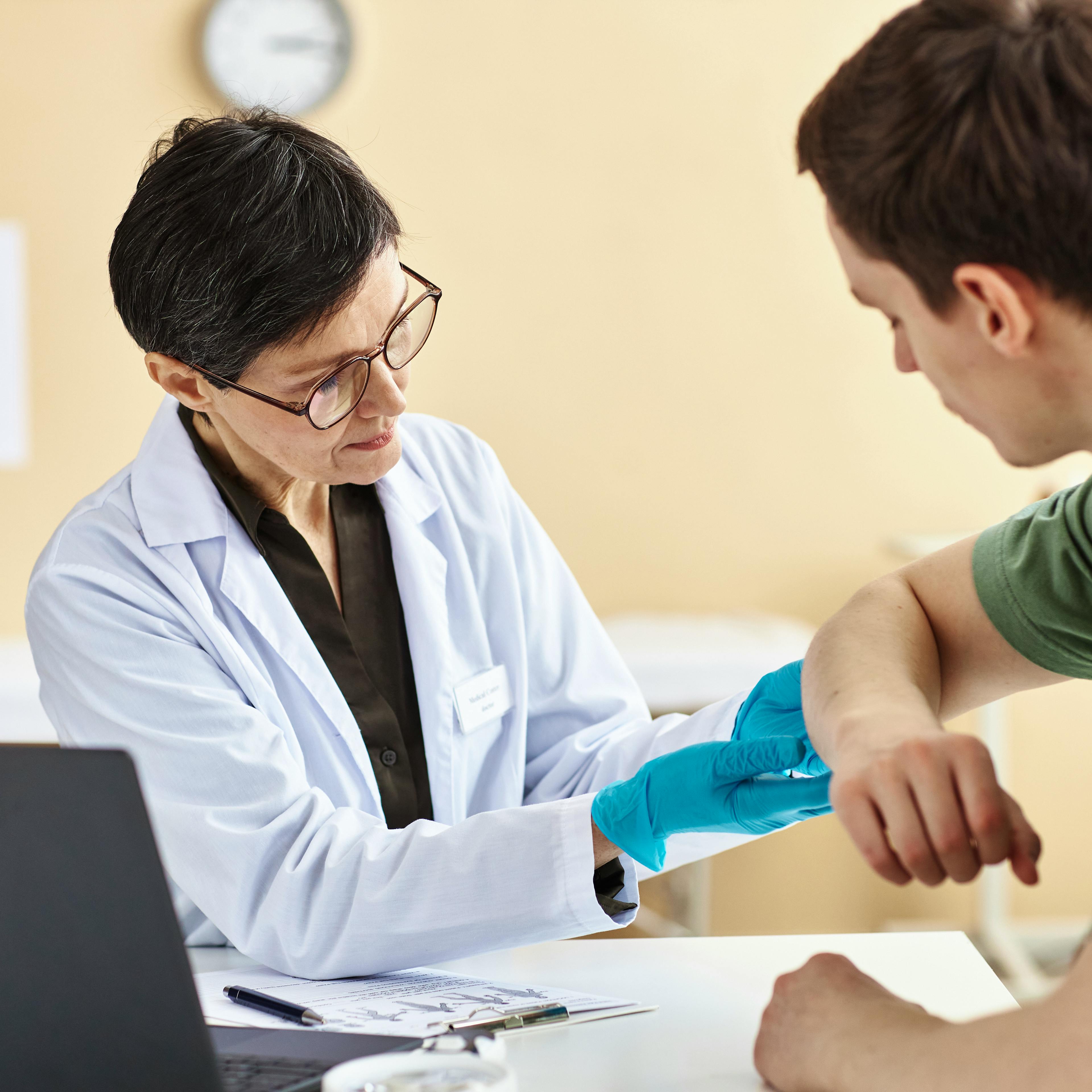 An allergist is giving a patient an allergy test.