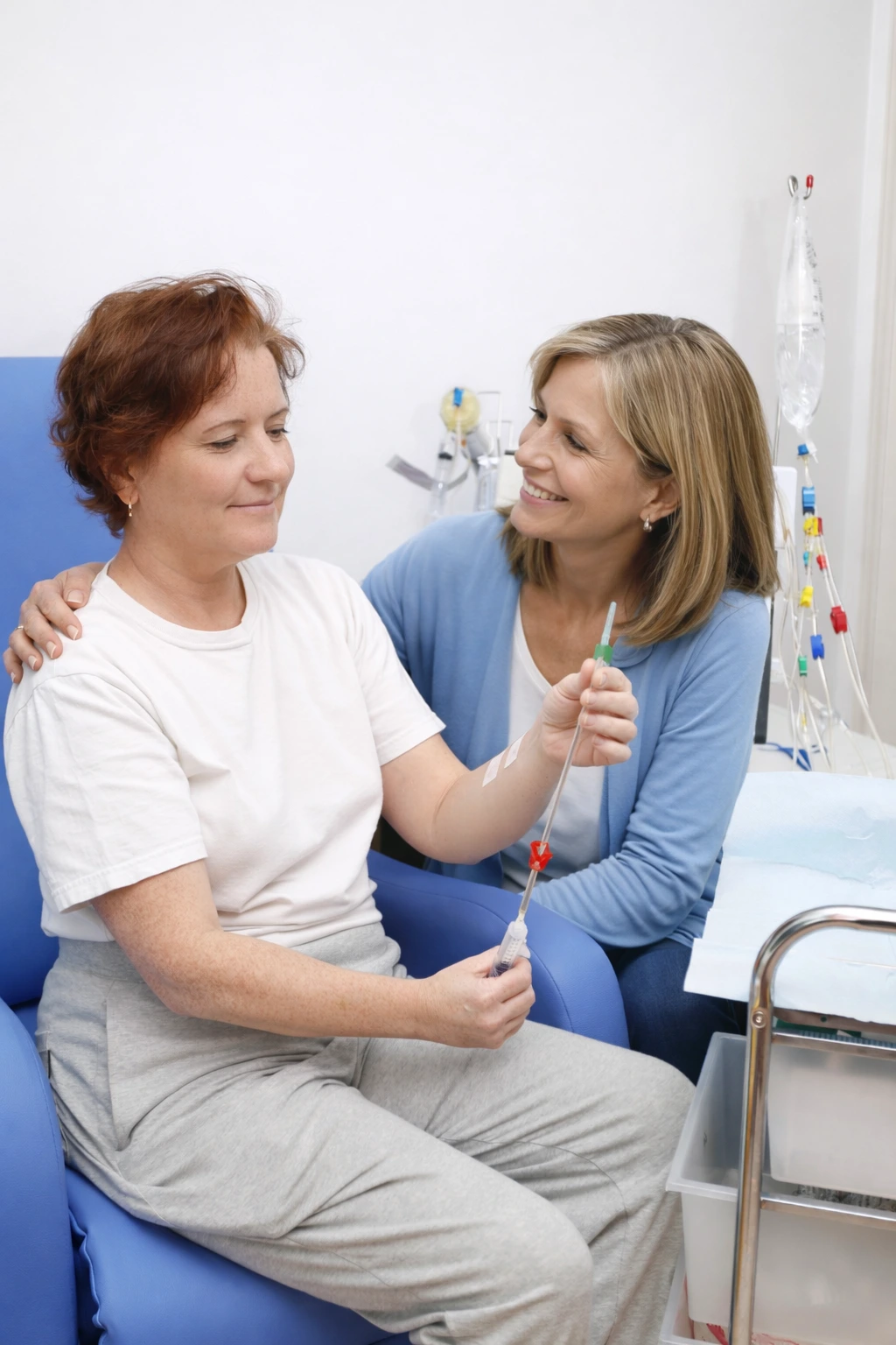 A middle-aged woman is doing home dialysis treatment. She is accompanied by a woman for moral support. 