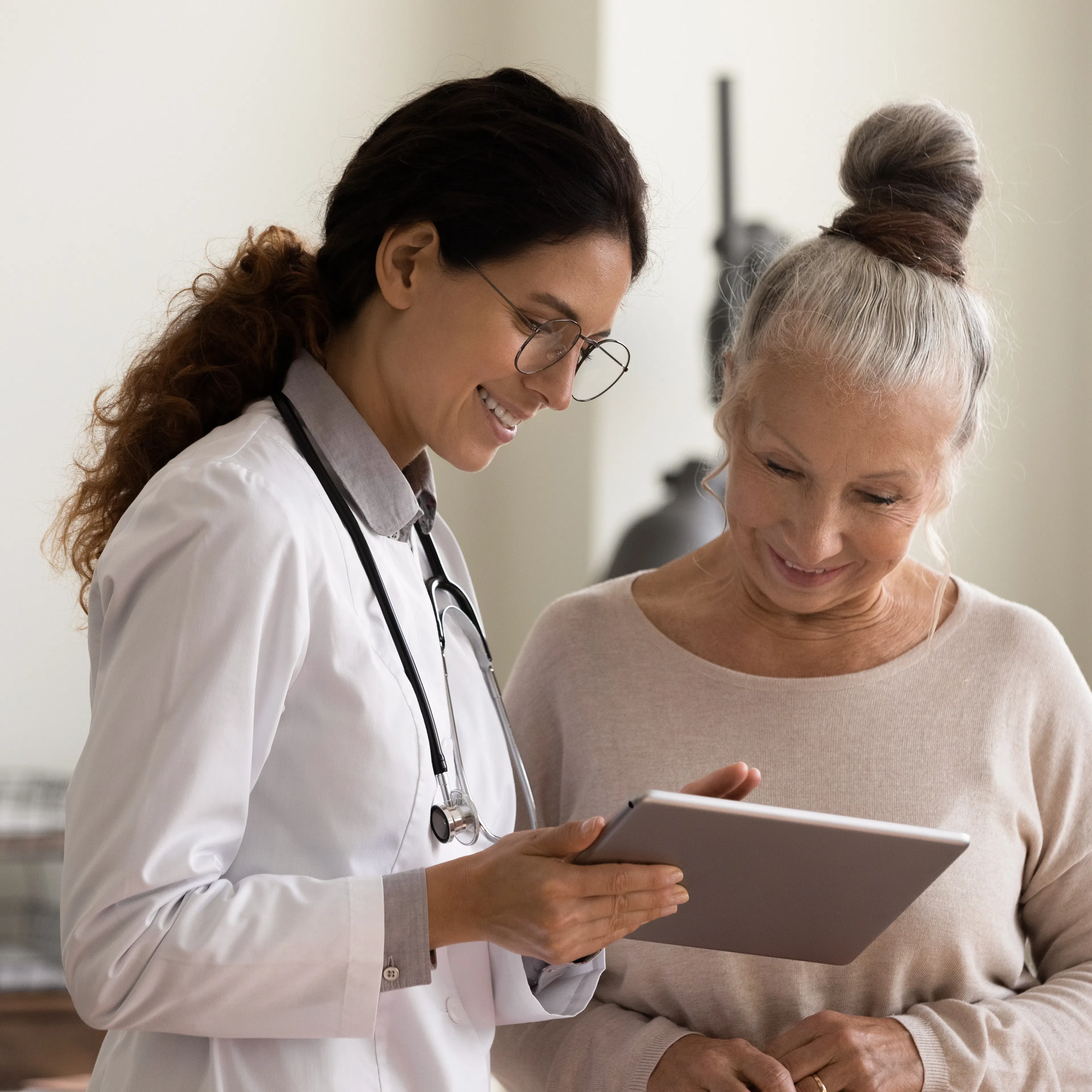 Female doctor and senior female patient are happily looking at a treatment plan together.