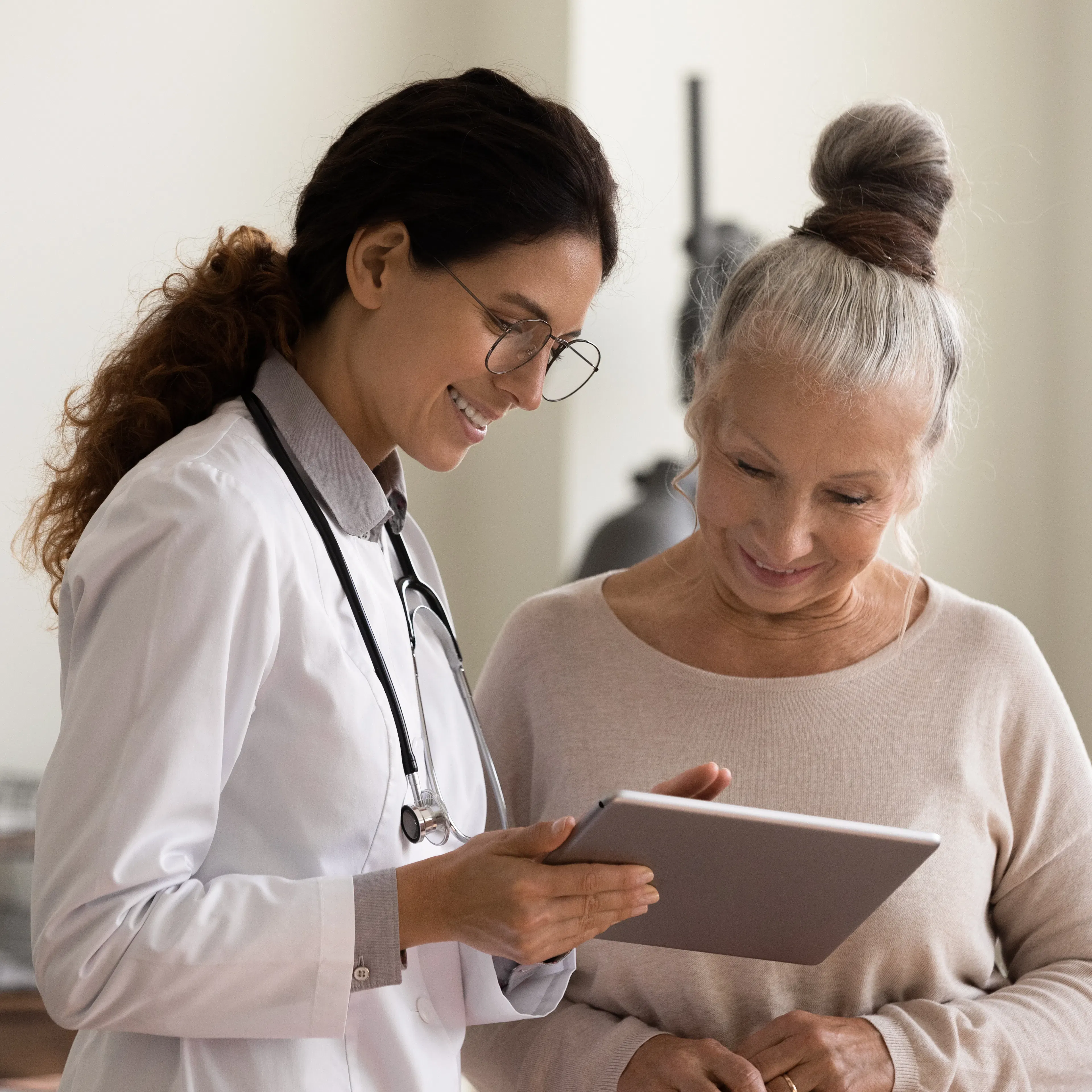 Female doctor and senior female patient are happily looking at a treatment plan together.