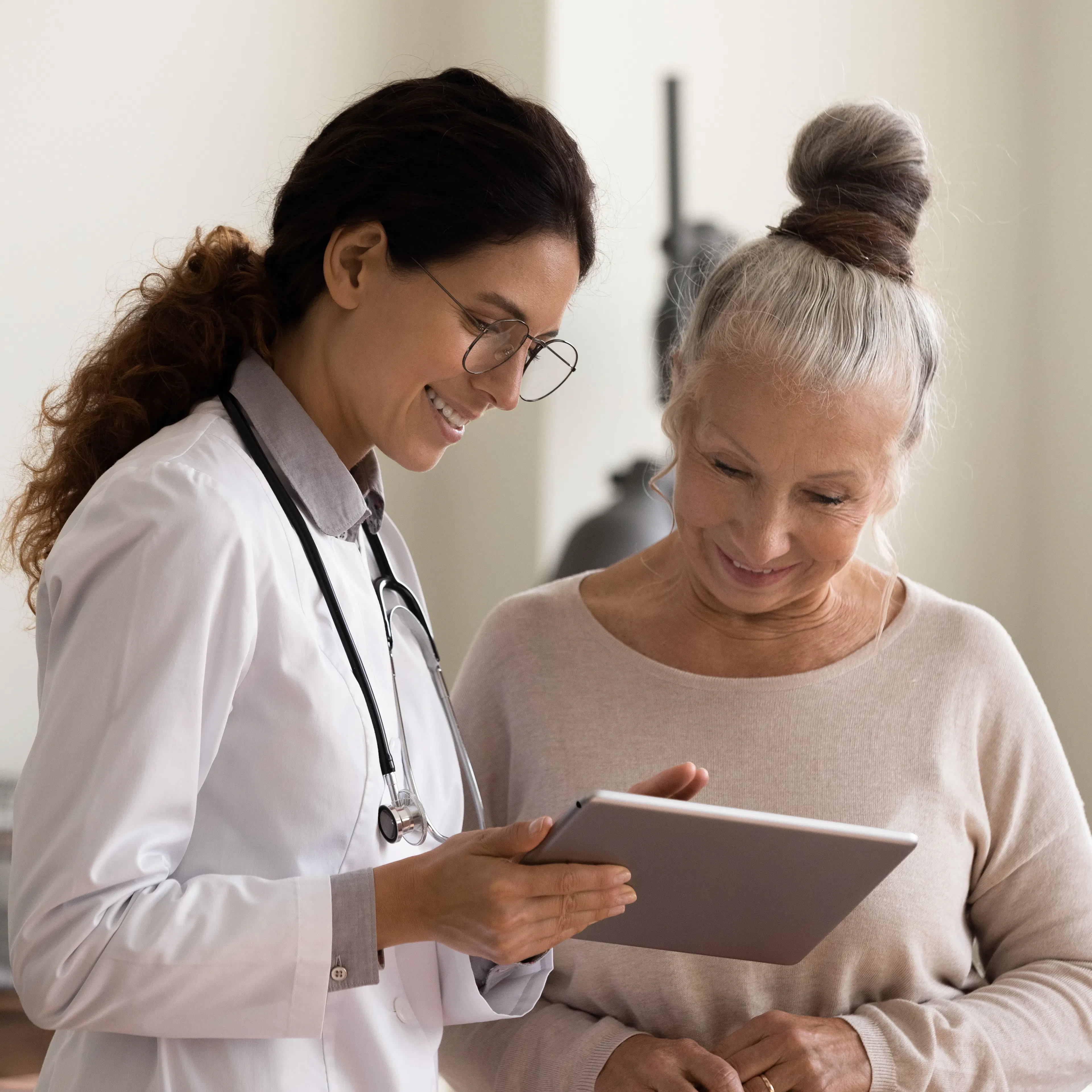 Female doctor and senior female patient are happily looking at a treatment plan together.