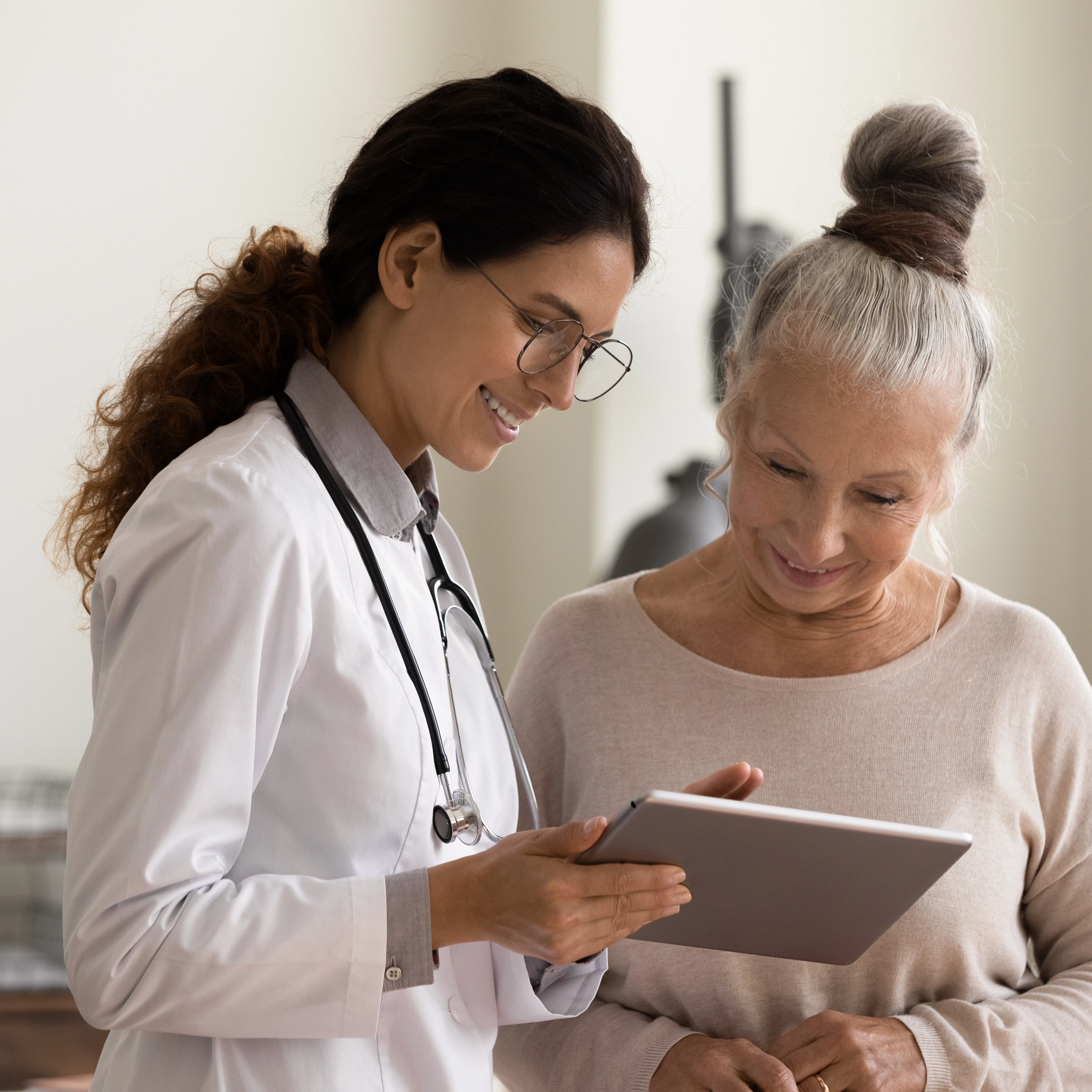 Female doctor and senior female patient are happily looking at a treatment plan together. 