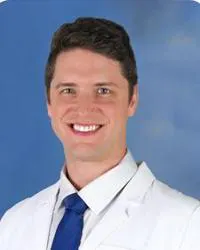 Jonathon Gordon Schening, MD, posing in his white coat for a headshot.