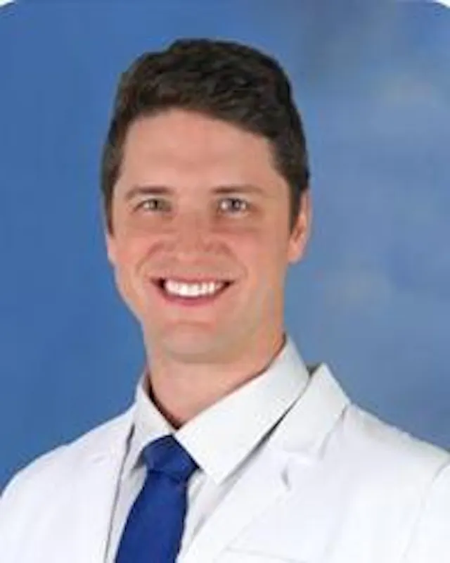 Jonathon Gordon Schening, MD, posing in his white coat for a headshot. 