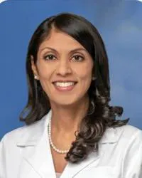 Silky Patel, MD, pain management specialist pictured in her white coat.