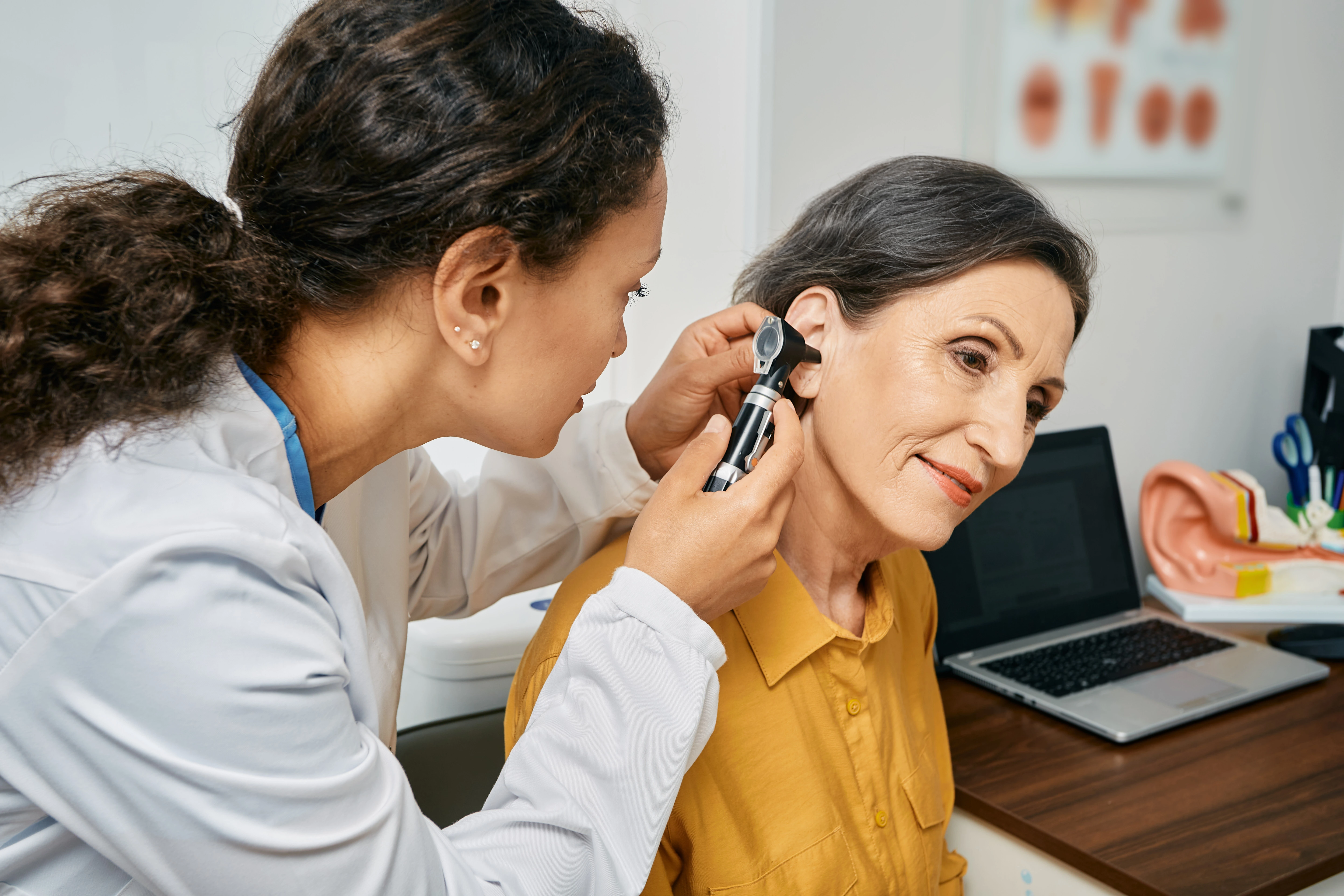 An ear, nose, and throat (ENT) doctor, also known as an otolaryngologist, checking a patient's ear. 