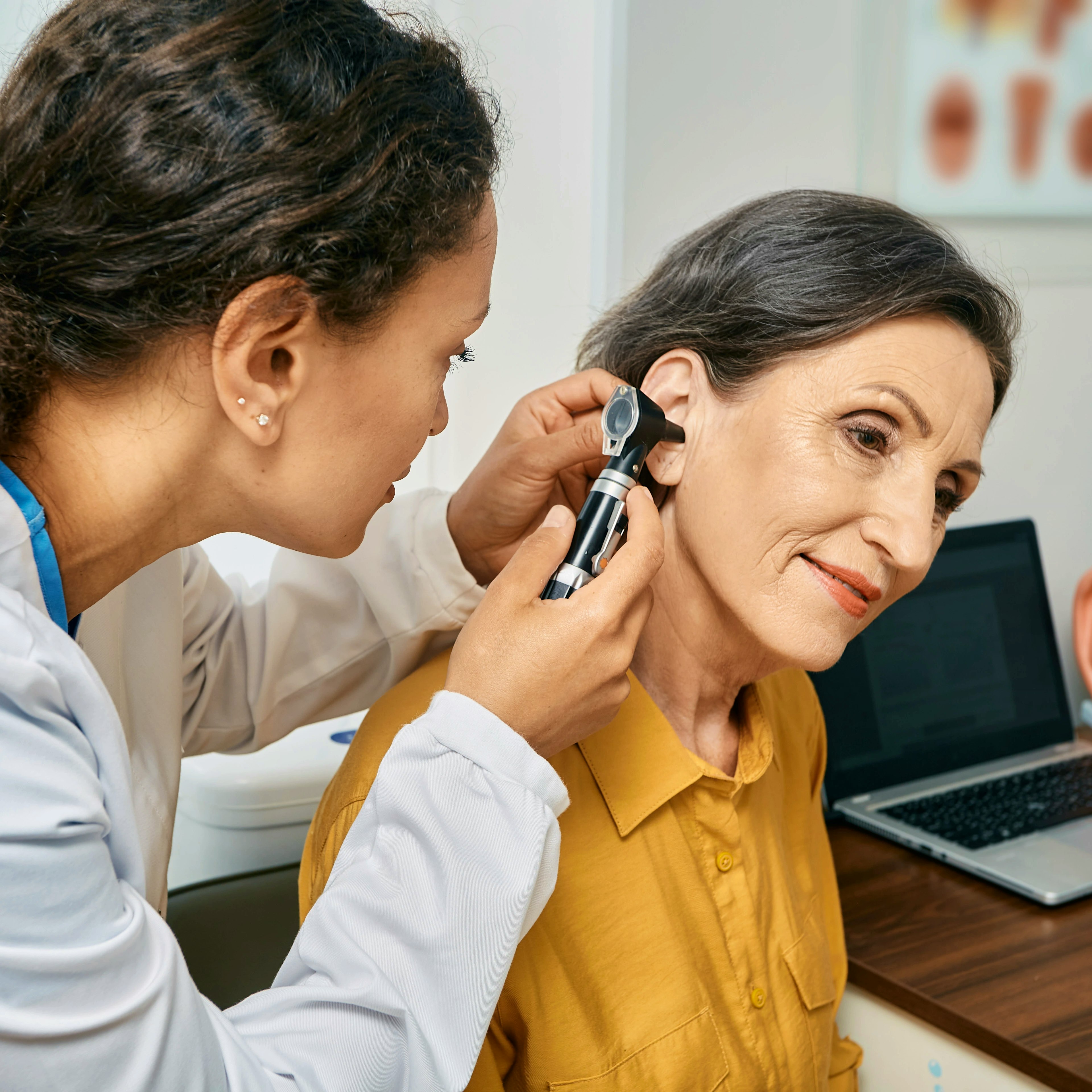 An ear, nose, and throat (ENT) doctor, also known as an otolaryngologist, checking a patient's ear.
