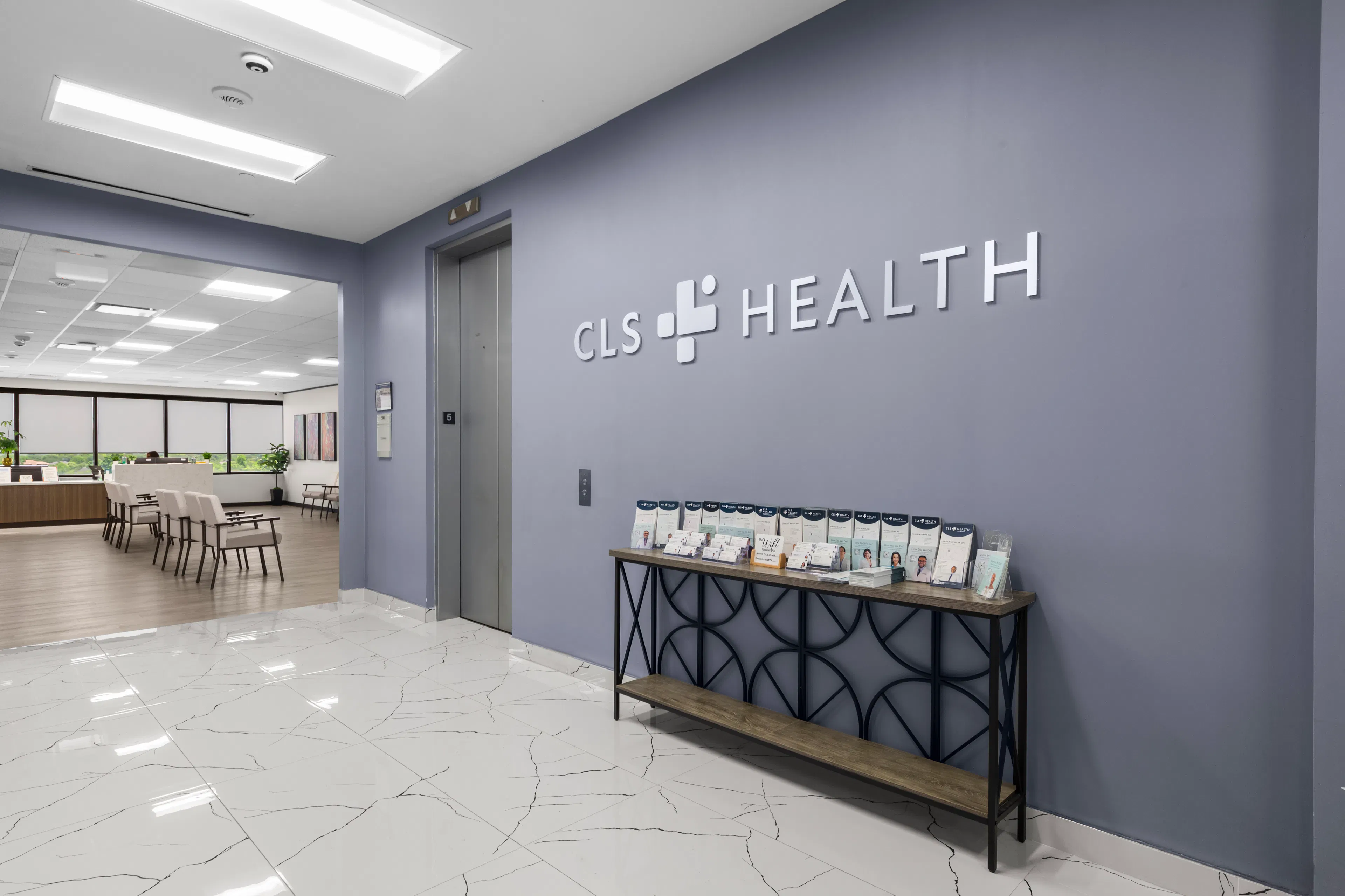 A CLS Health sign on the wall before the entrance to the waiting room at the Sugar Land location.