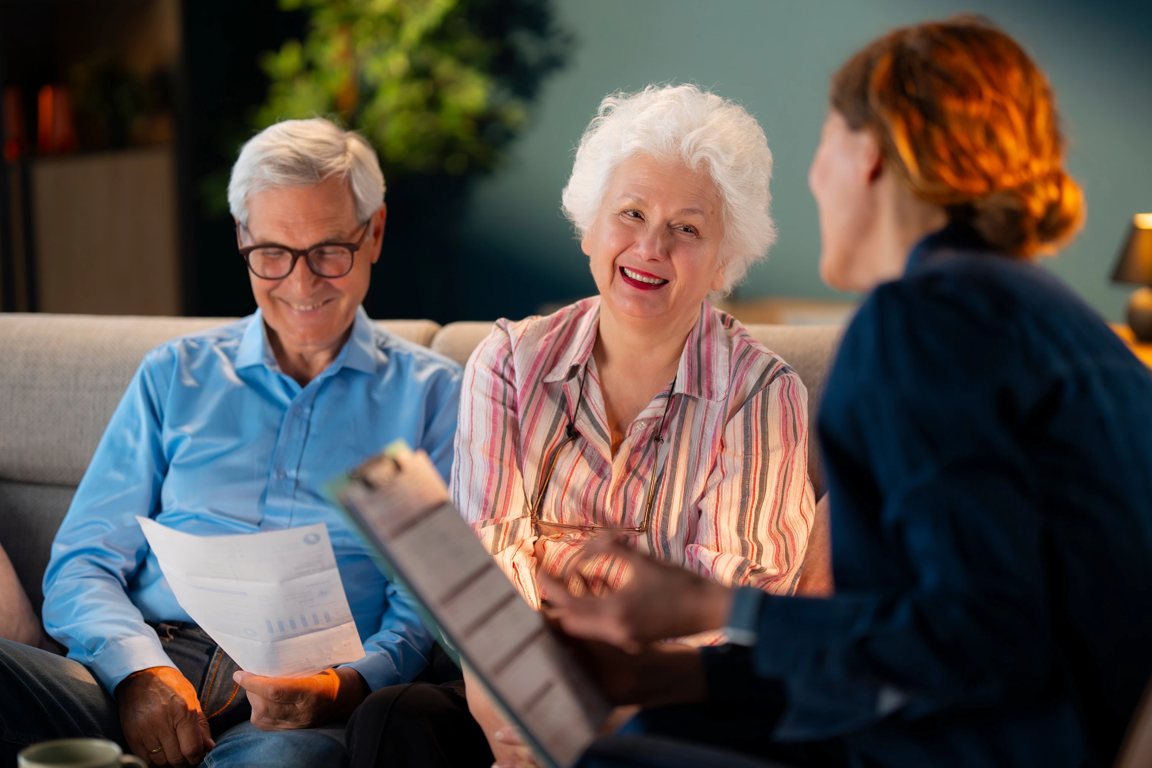 An elderly man and woman are discussing their Medicare coverage with an advisor.