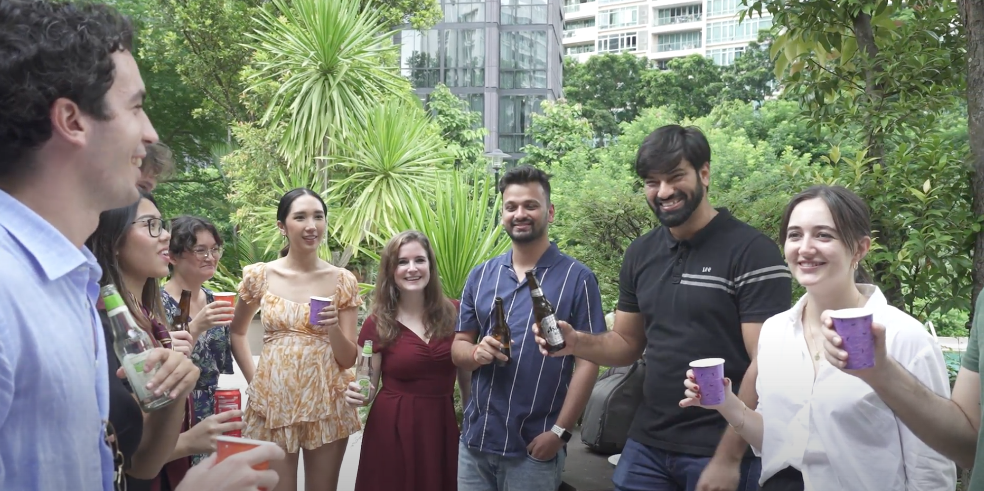 Casa Mia members, cheering, drinks, outside, greenery