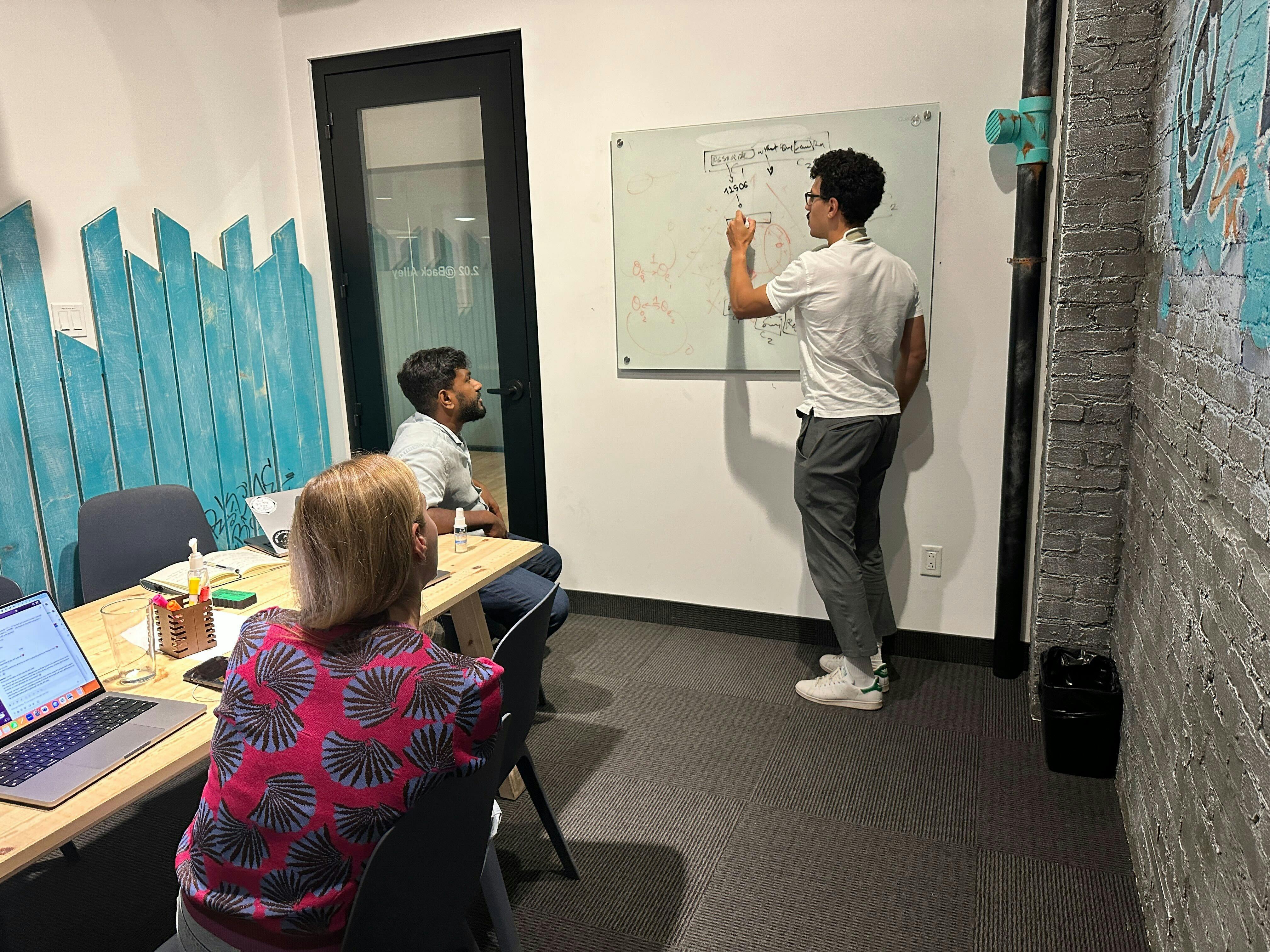 Malik explaining an idea to Coactive team members in the Montreal office.