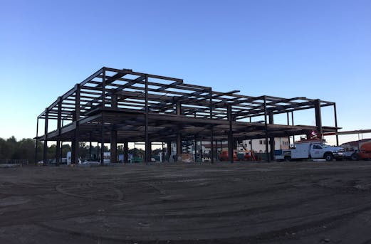 Galvanized steel framework serving as scaffolding for a large building, showcasing durable corrosion protection through galvanizing by Coatinc US.