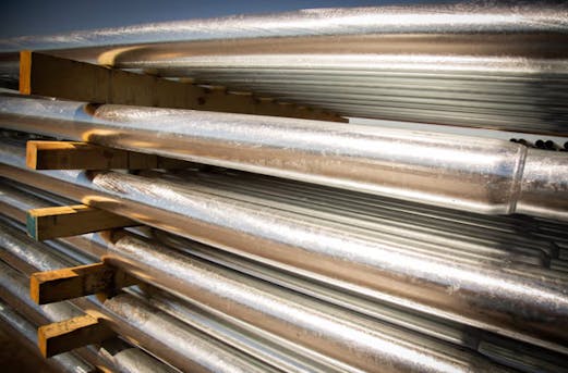Stack of galvanized steel pipes, representing the future of pole galvanizing by Coatinc US with durable, scalable, and sustainable corrosion protection solutions.
