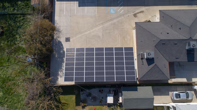 House with a large carport topped with solar panels, supported by galvanized steel structures for durable corrosion protection by Coatinc US.