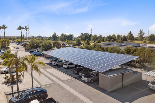 Large parking lot with numerous carports topped with solar panels, supported by galvanized steel structures for durable protection by Coatinc US.