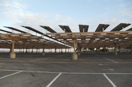 Large parking zone with steel roof structures and solar panels on top, supported by galvanized steel constructions for durable protection by Coatinc US.