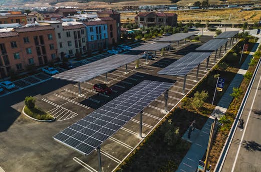 Large parking canopies with solar panels mounted on galvanized steel structures, showcasing standout corrosion protection by Coatinc US in Arizona, Utah, and Nevada.