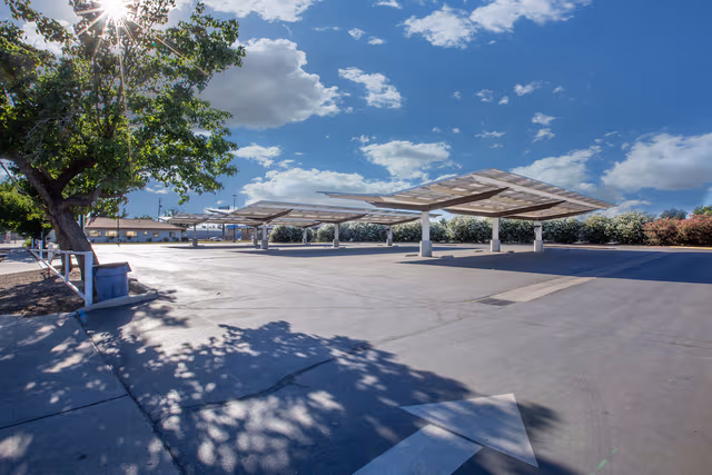 Large parking lot with solar canopies supported by galvanized steel structures, showcasing durable corrosion protection by Coatinc US.