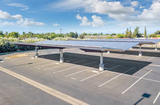 Custom solar carport solution over a large parking lot, featuring galvanized steel structures and rooftop solar panels protected by Coatinc US.