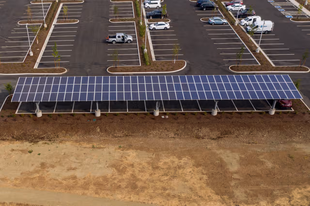Large solar carport installed in a parking area, supported by galvanized steel structures protected by Coatinc US.