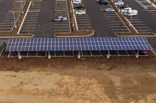 Large solar carport installed in a parking area, supported by galvanized steel structures protected by Coatinc US.
