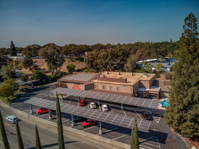 Company parking area with solar-covered carports supported by galvanized steel structures, highlighting the benefits of partnering with Coatinc US for durable protection.