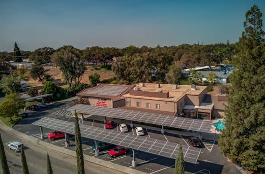 Company parking area with solar-covered carports supported by galvanized steel structures, highlighting the benefits of partnering with Coatinc US for durable protection.