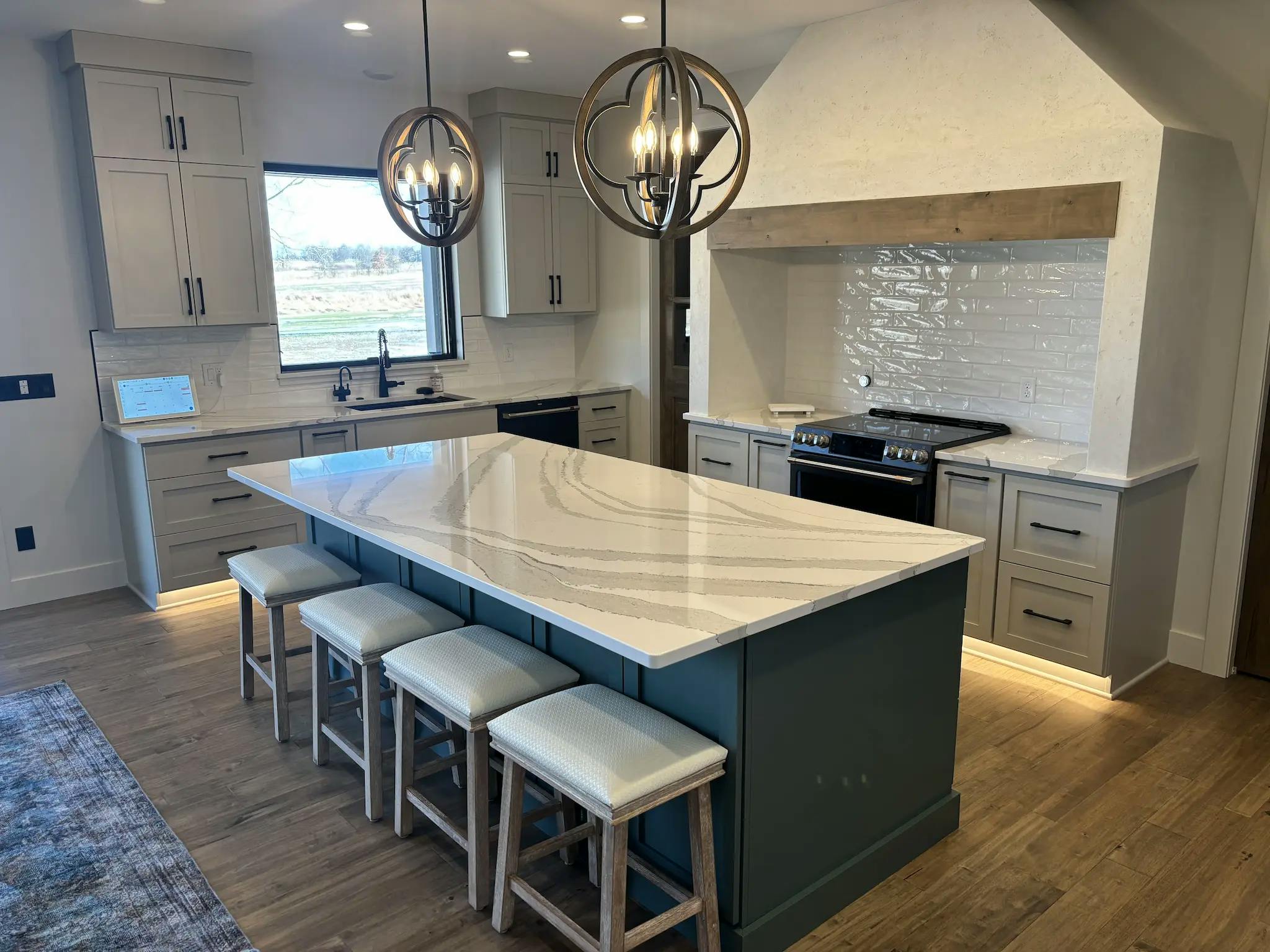 A modern kitchen featuring a central island with bar stools arranged around it for casual dining and socializing