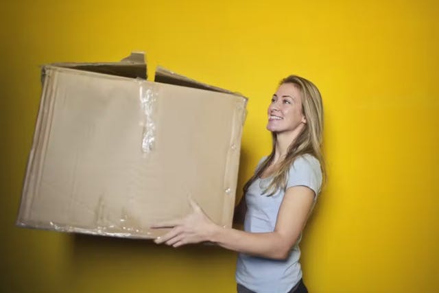 femme portant un carton