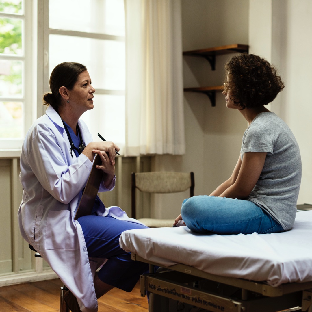 A doctor is speaking with a patient in an Australian exam room. 