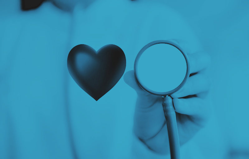A healthcare professional holds a stethoscope, with a heart symbol alongside, representing care and concern for health and wellness.