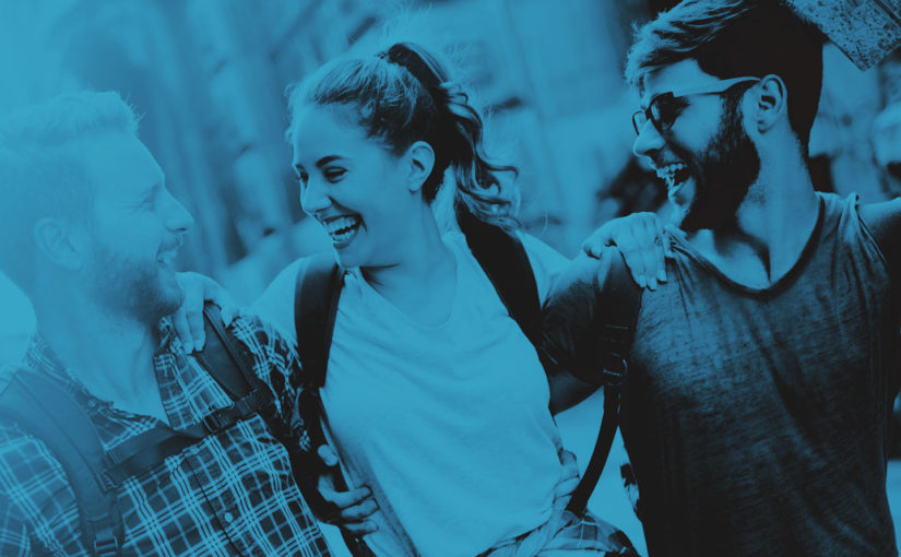 Three friends laughing and enjoying time together in a lively outdoor setting.