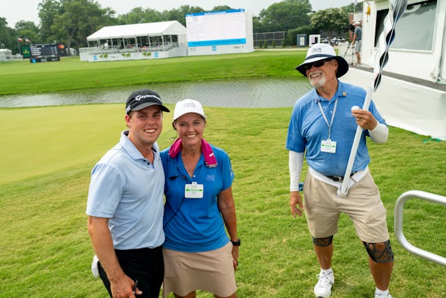 3 volunteers smiling on course