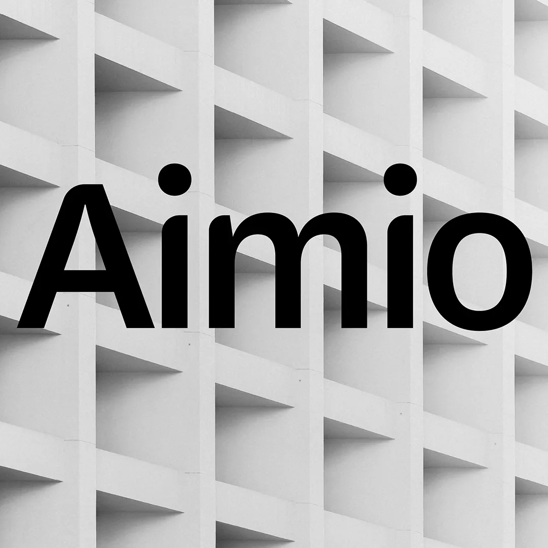 Texte « Aimio » en noir, centré sur un fond gris composé de motifs géométriques en relief en forme de grilles.