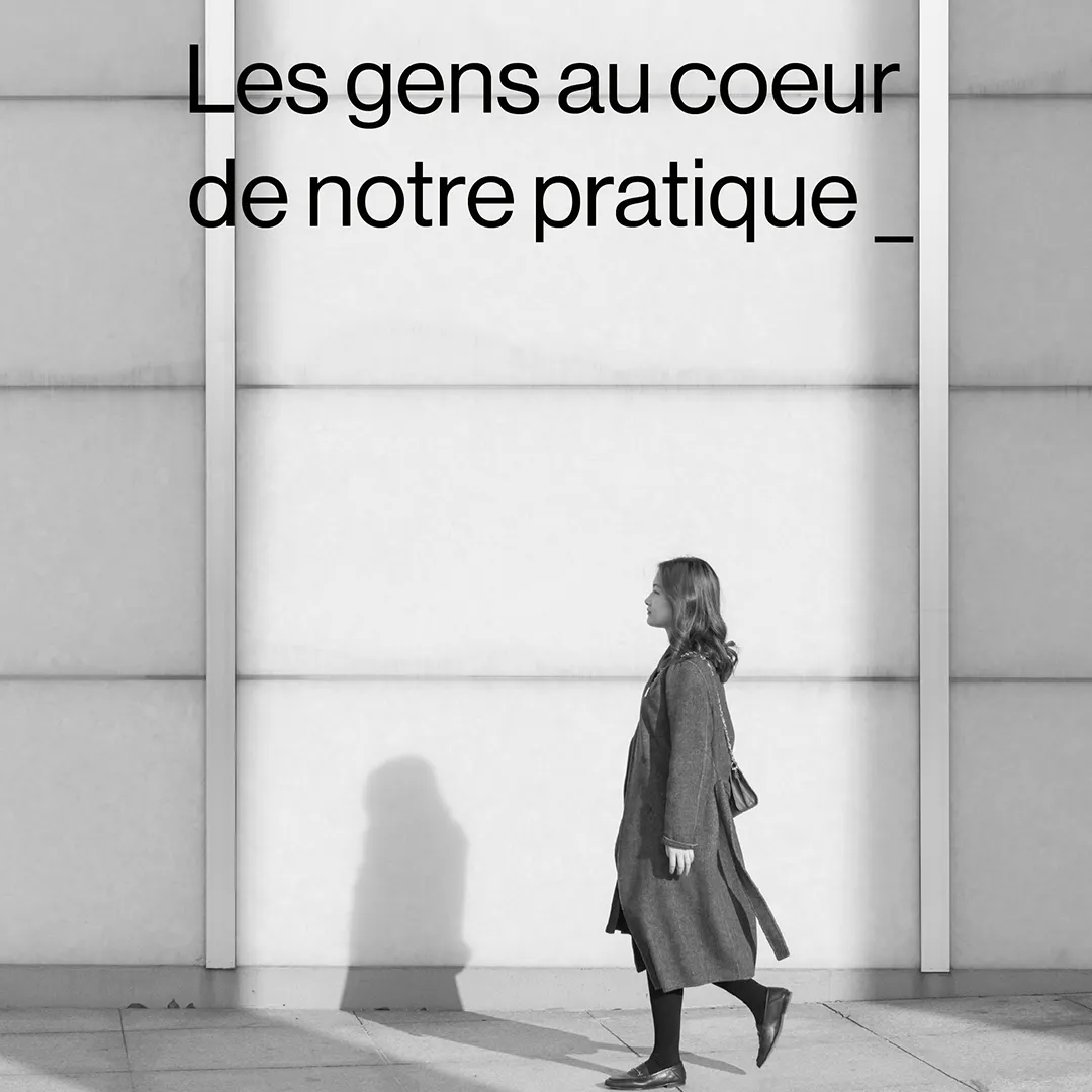 Femme marchant de profil devant un mur clair, projetant une ombre au sol, avec le texte « Les gens au cœur de notre pratique » en haut.