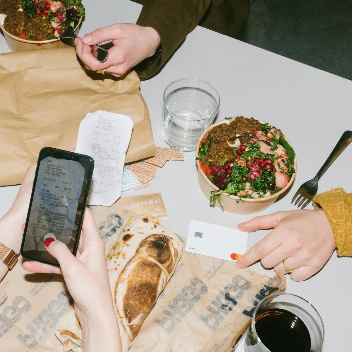 Eine Gruppe von Leuten, die Pleos Belegscanner benutzen, um ihre Ausgaben für das Abendessen zu erfassen