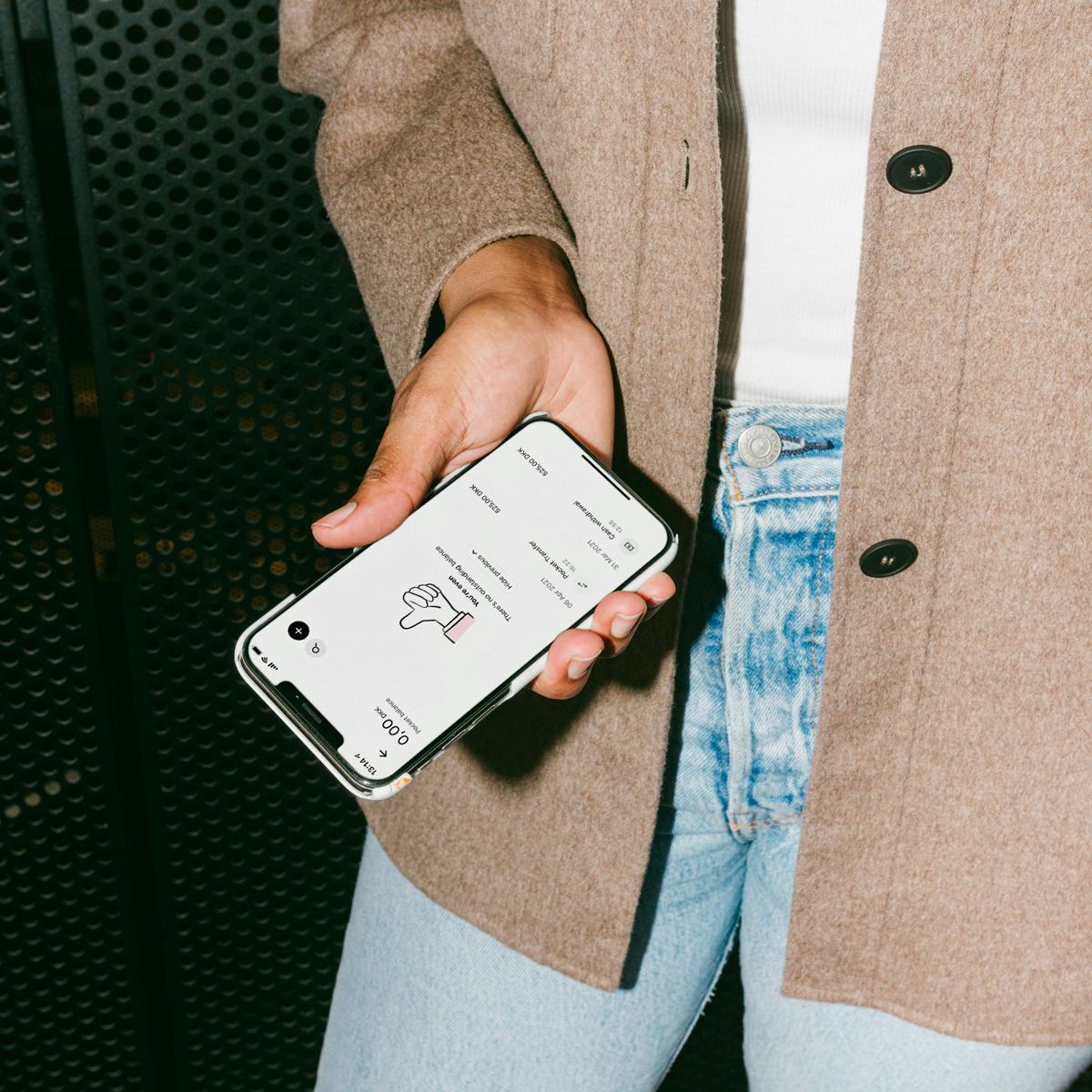 En person som holder en telefon med Pleo-appen installert