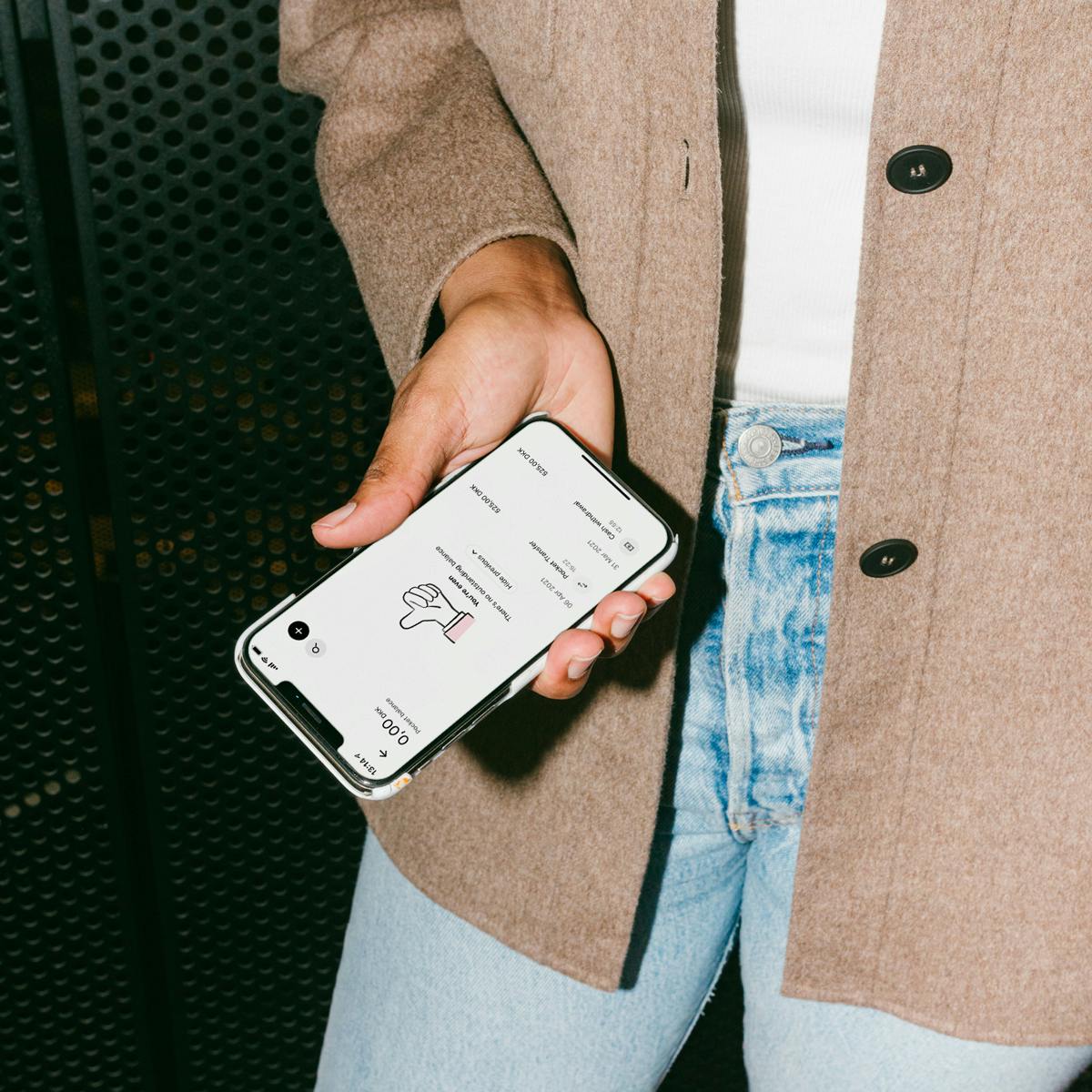 A person holds a phone with Pleo app on it