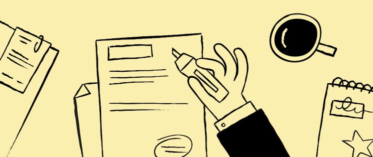 Hand holding a pen over documents