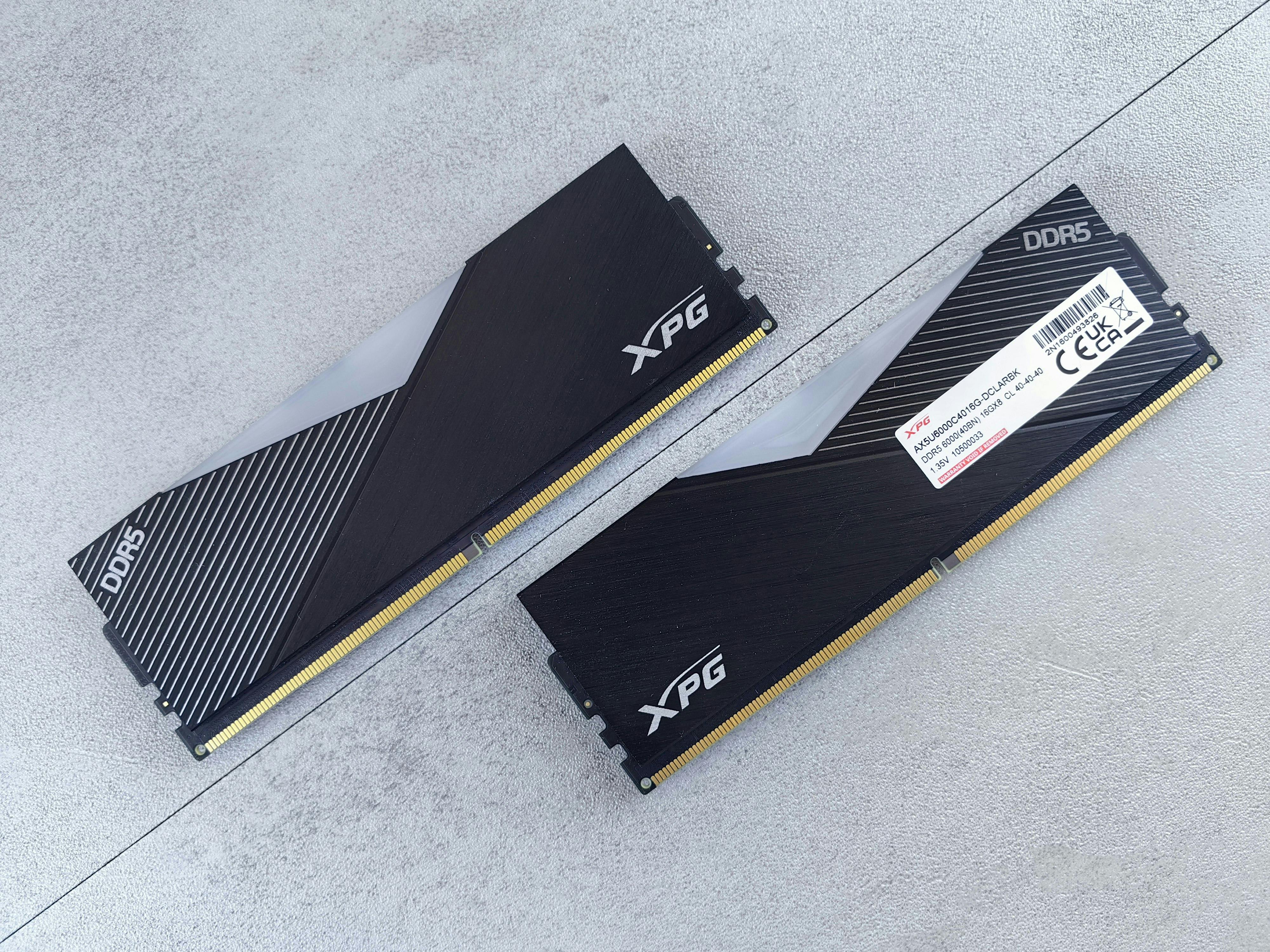 Photo d’un ordinateur de bureau ouvert montrant plusieurs barrettes de RAM installées sur la carte mère, avec un éclairage RGB subtil et un environnement de travail moderne.