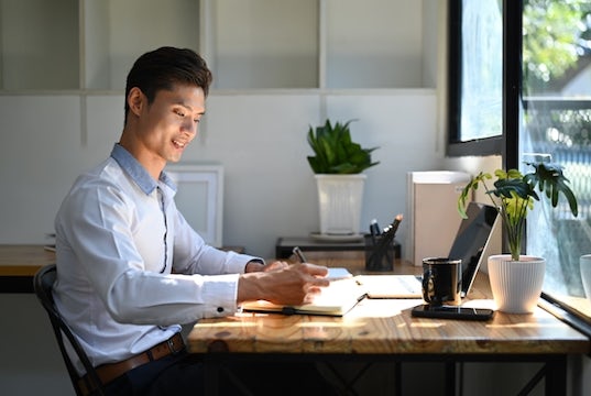 Business owner sits at his desk in his home office