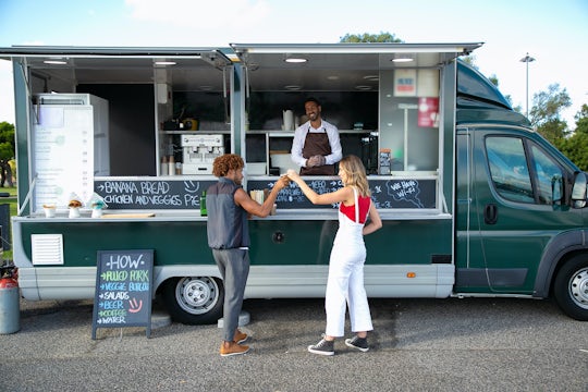 Two customers visit a food truck