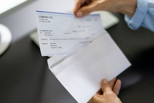 An employee examines their paycheck